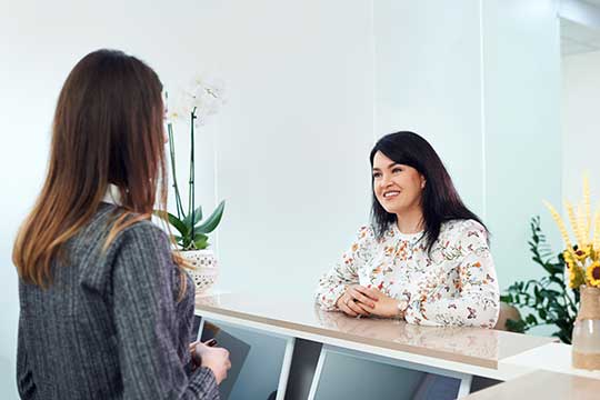 Woman at reception counter of hearing aid center.